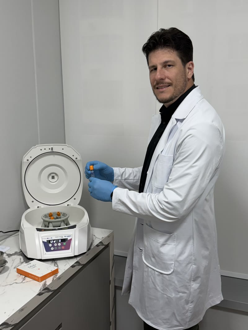 Dr. Rúbio Arruda com o tubo de PRP ao lado da centrífuga, no consultório em Copacabana
